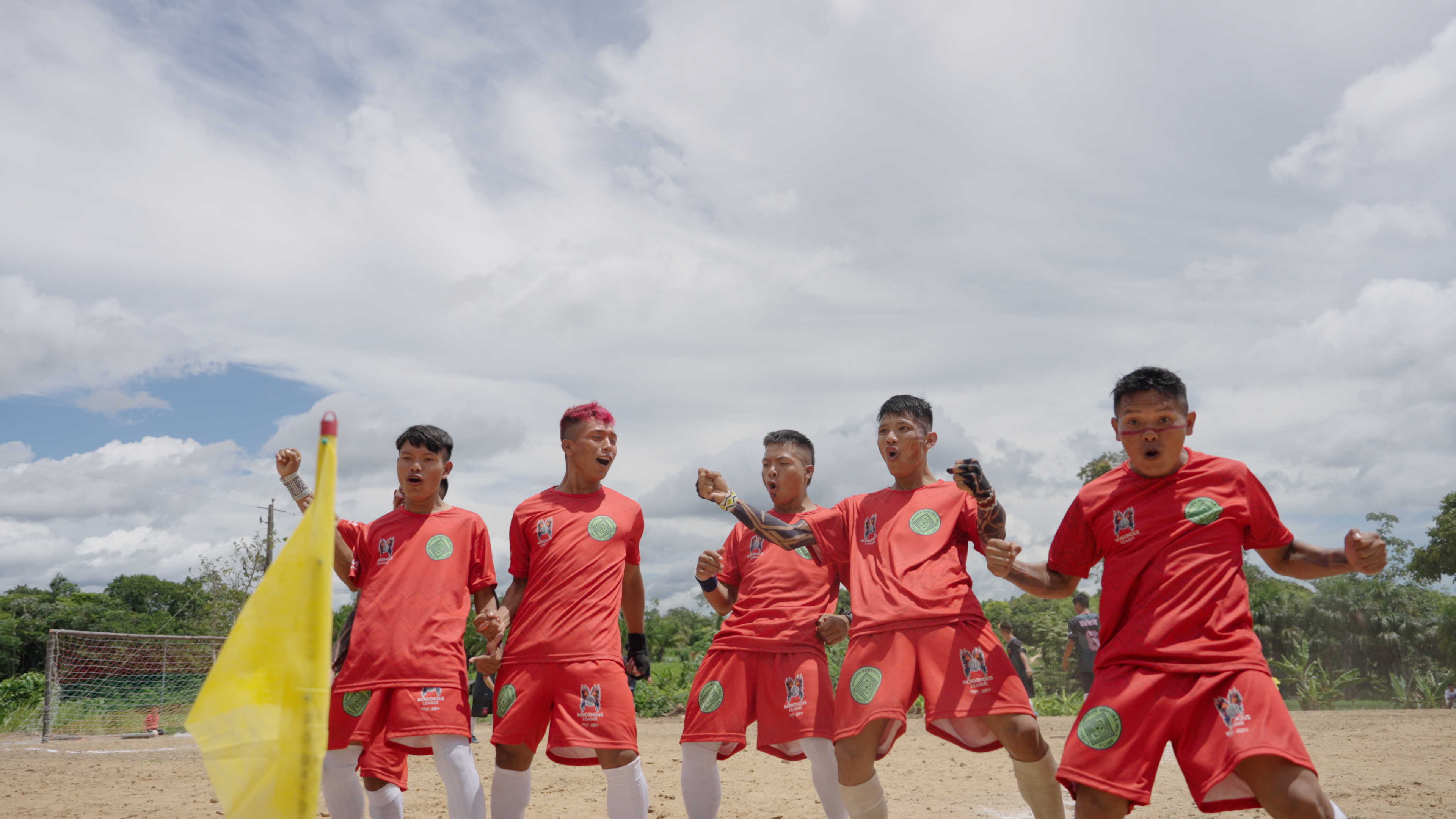 Young Indigenous players celebrating together on the dirt field