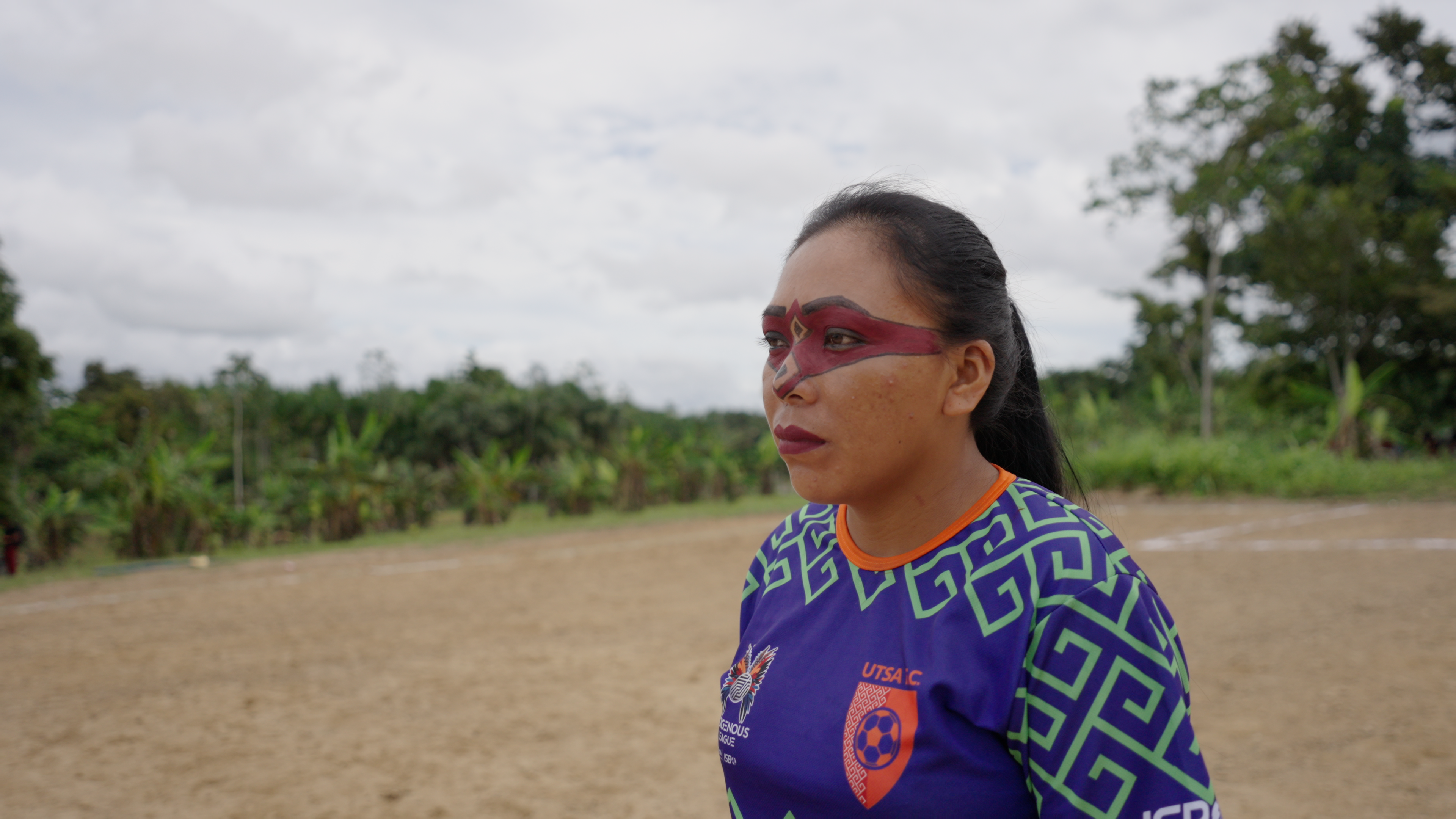 Indigenous woman athlete with red face paint on the field