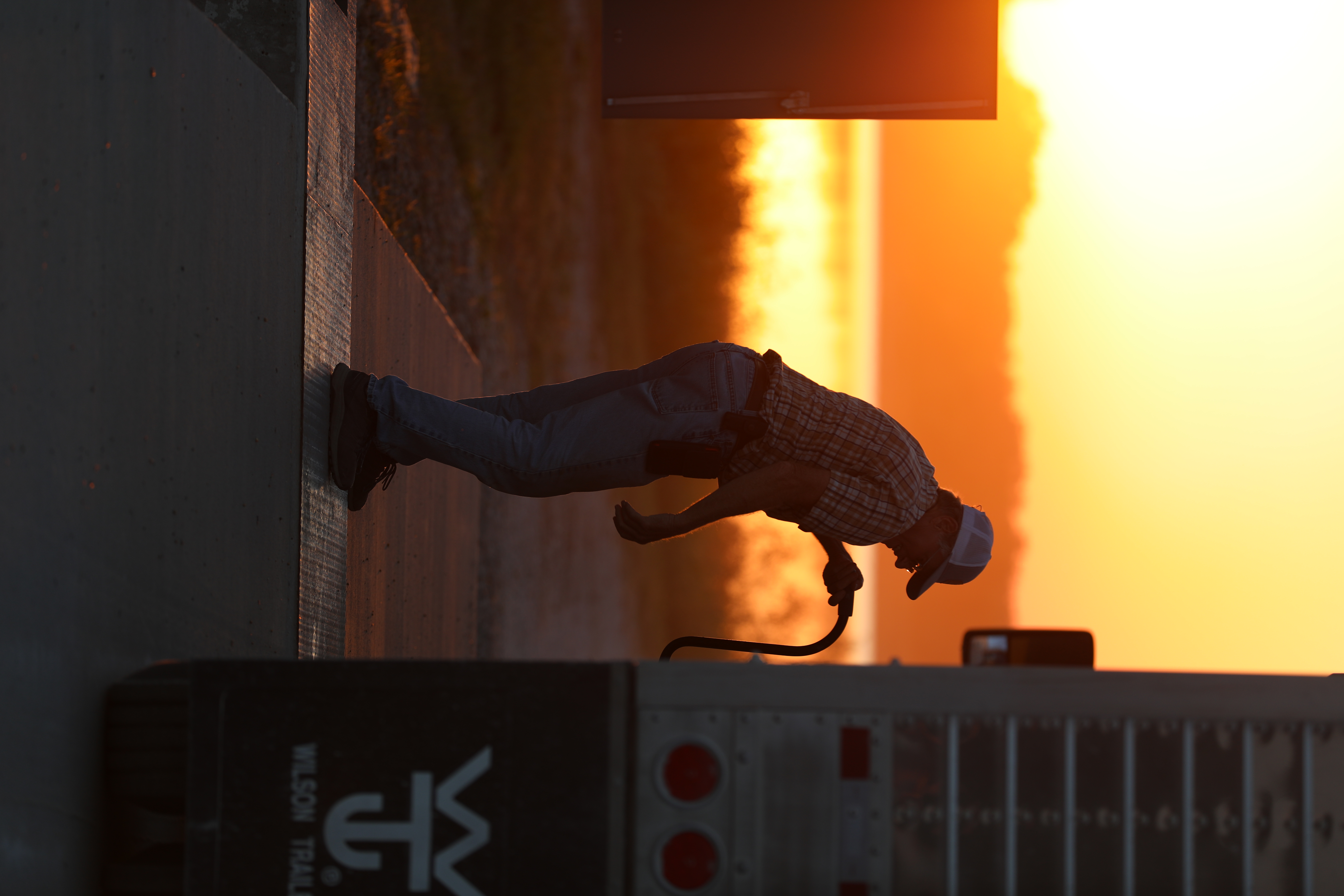 Operator leaning into a Wilson trailer at sunset