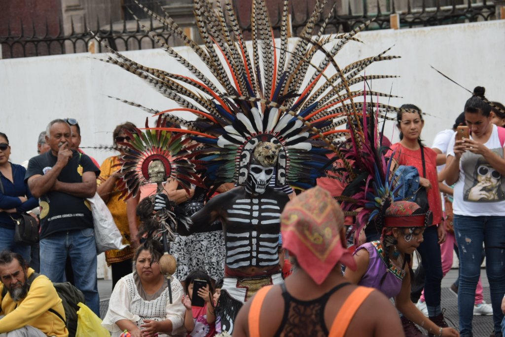 Aztec dancer with skeleton body paint and towering feather headdress