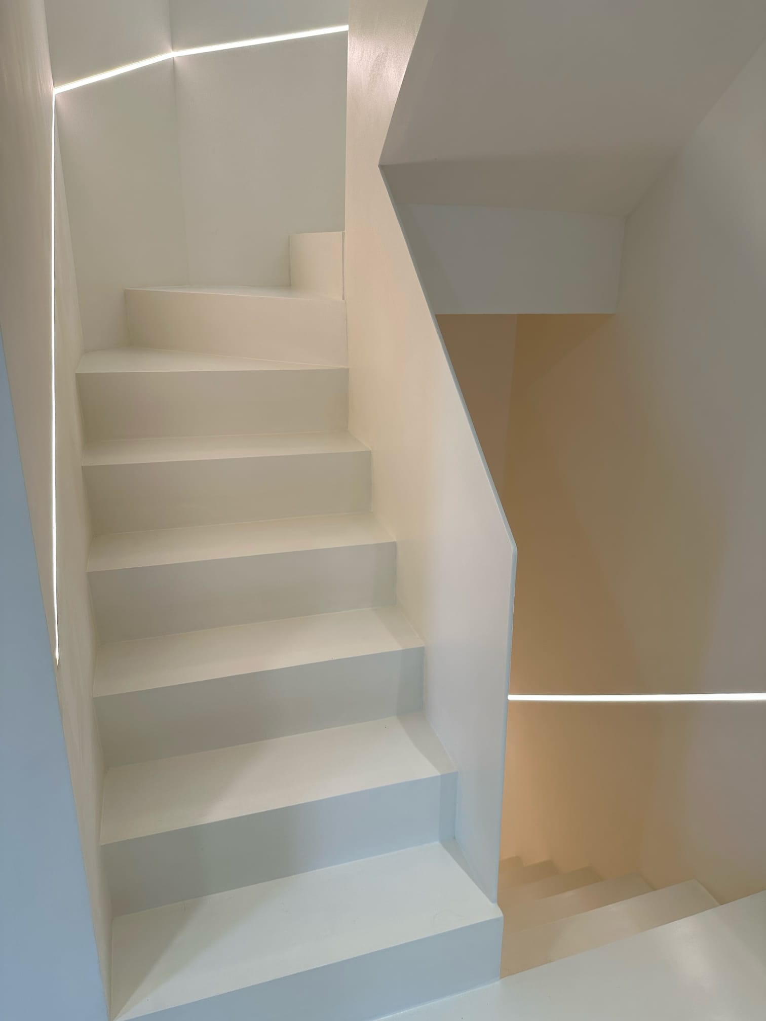 Naadloze microcement trap met geïntegreerde LED-verlichting in de wand