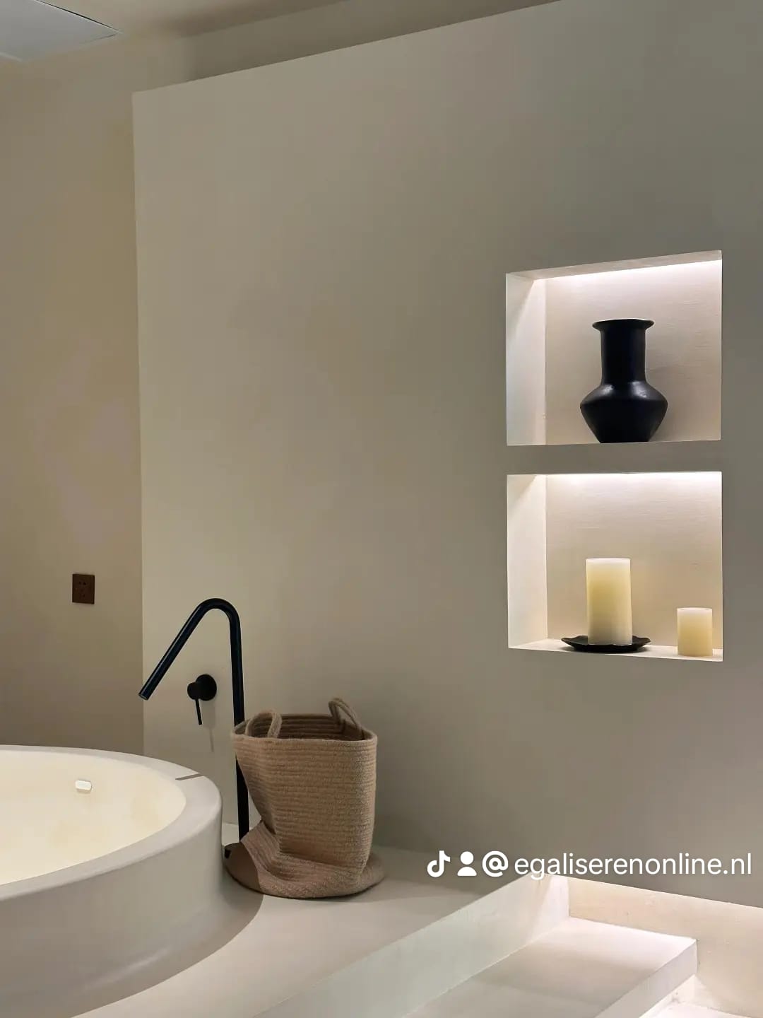 Microcement badkamer met ingebouwde wandnissen en warme LED-verlichting