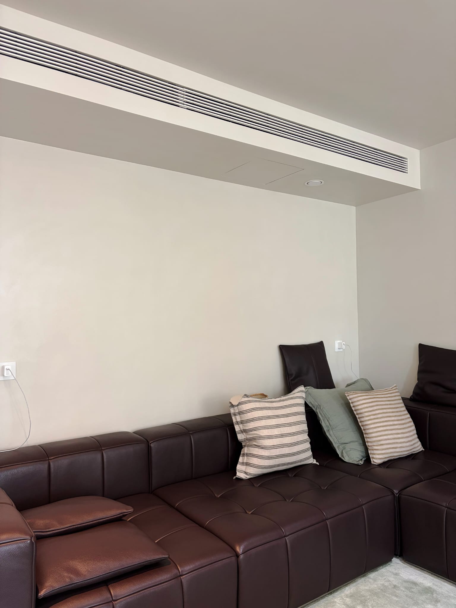Microcement wand met bank en naadloze afwerking in lichte tint