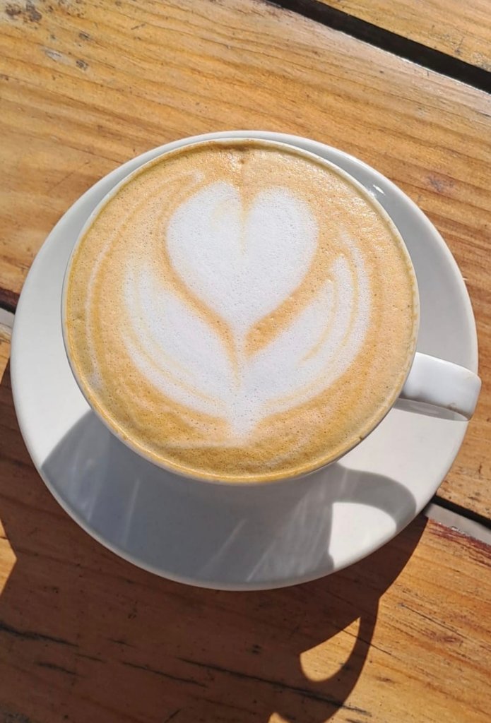 Latte art coffee cup on wooden table