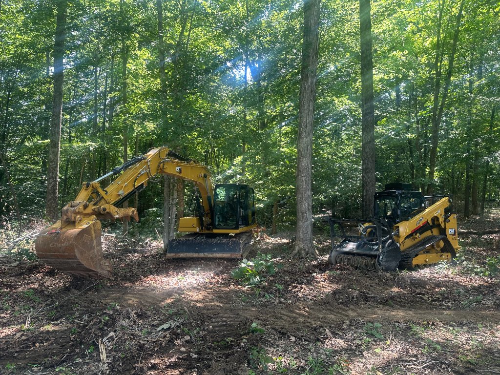 Back 40 Land Services full equipment deployment — CAT 313 excavator and CAT 275 forestry skid steer clearing multi-acre wooded site in Middle Tennessee