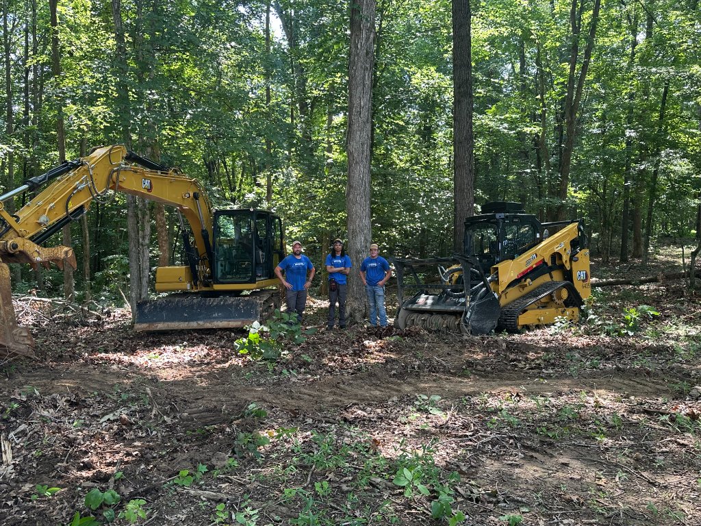 Back 40 Land Services crew standing with CAT 313 excavator and CAT 275 skid steer in Middle Tennessee