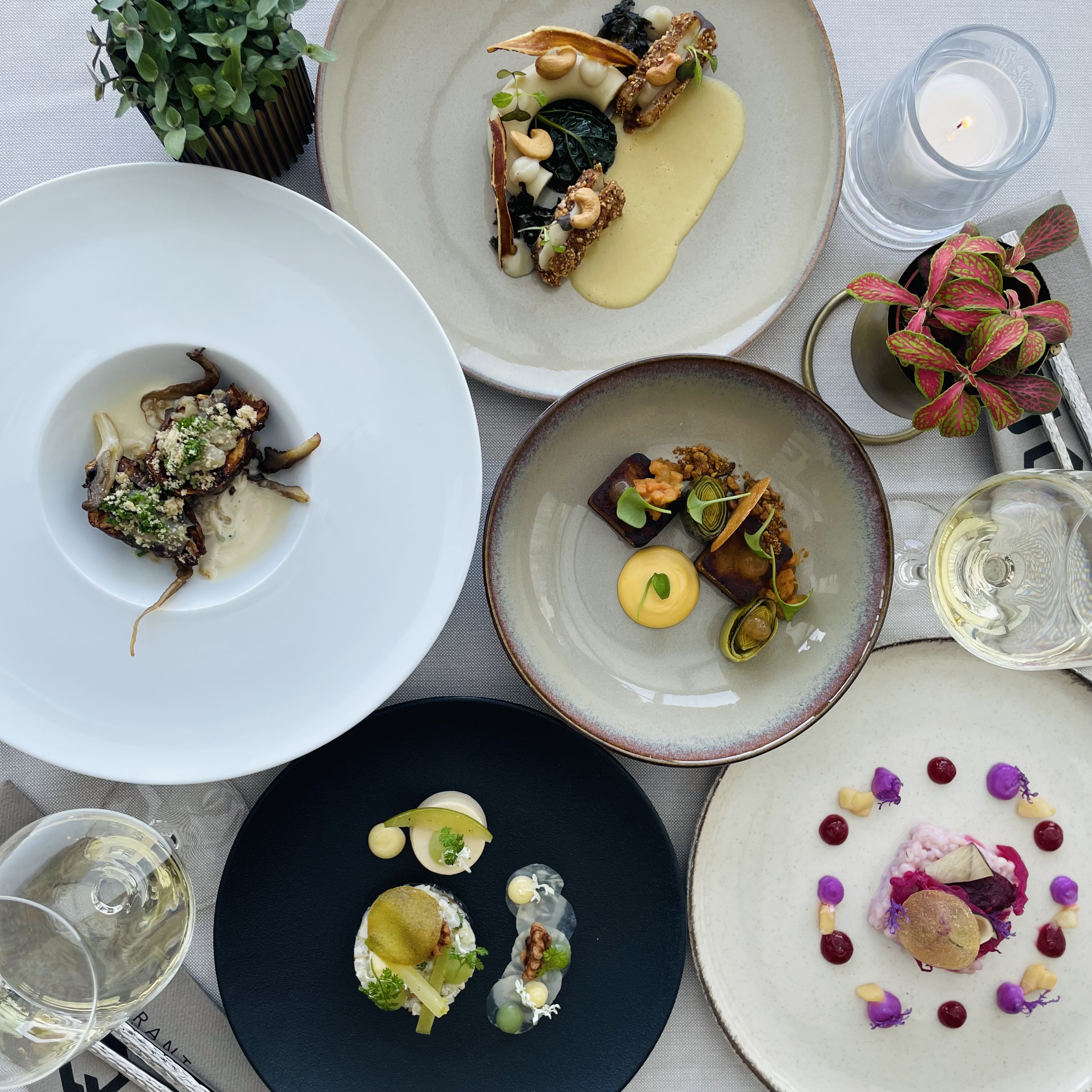 Wisselende vegetarische en vegan gerechten van Restaurant LUQS op een gedekte tafel