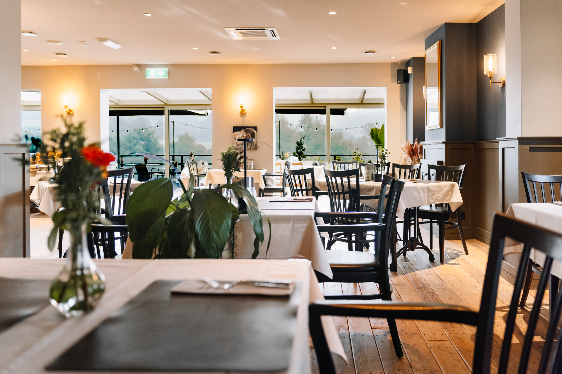 Restaurant LUQS eetzaal met gedekte tafels en uitzicht over het Heuvelland