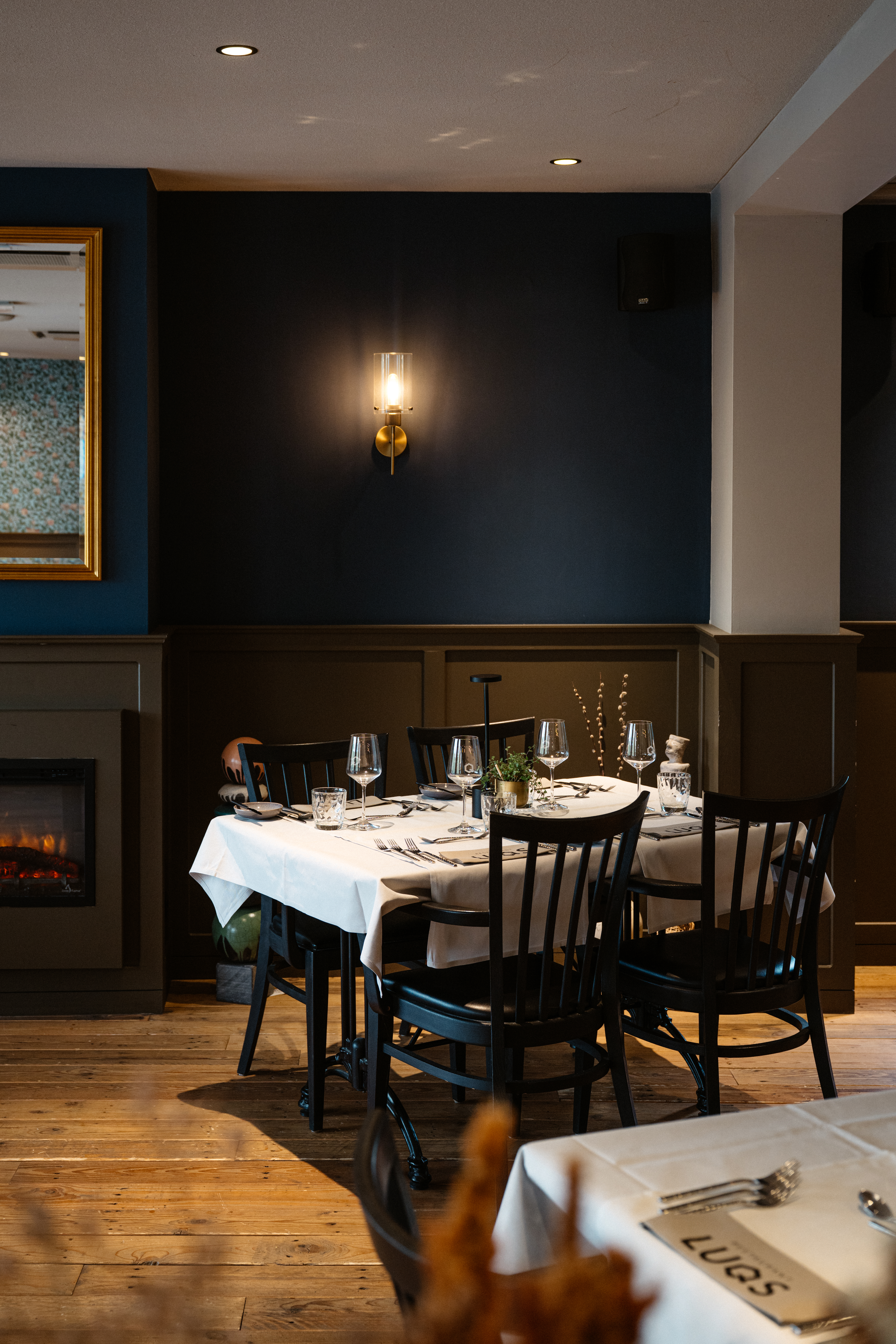 Gedekte tafel in Restaurant LUQS voor een brandende open haard