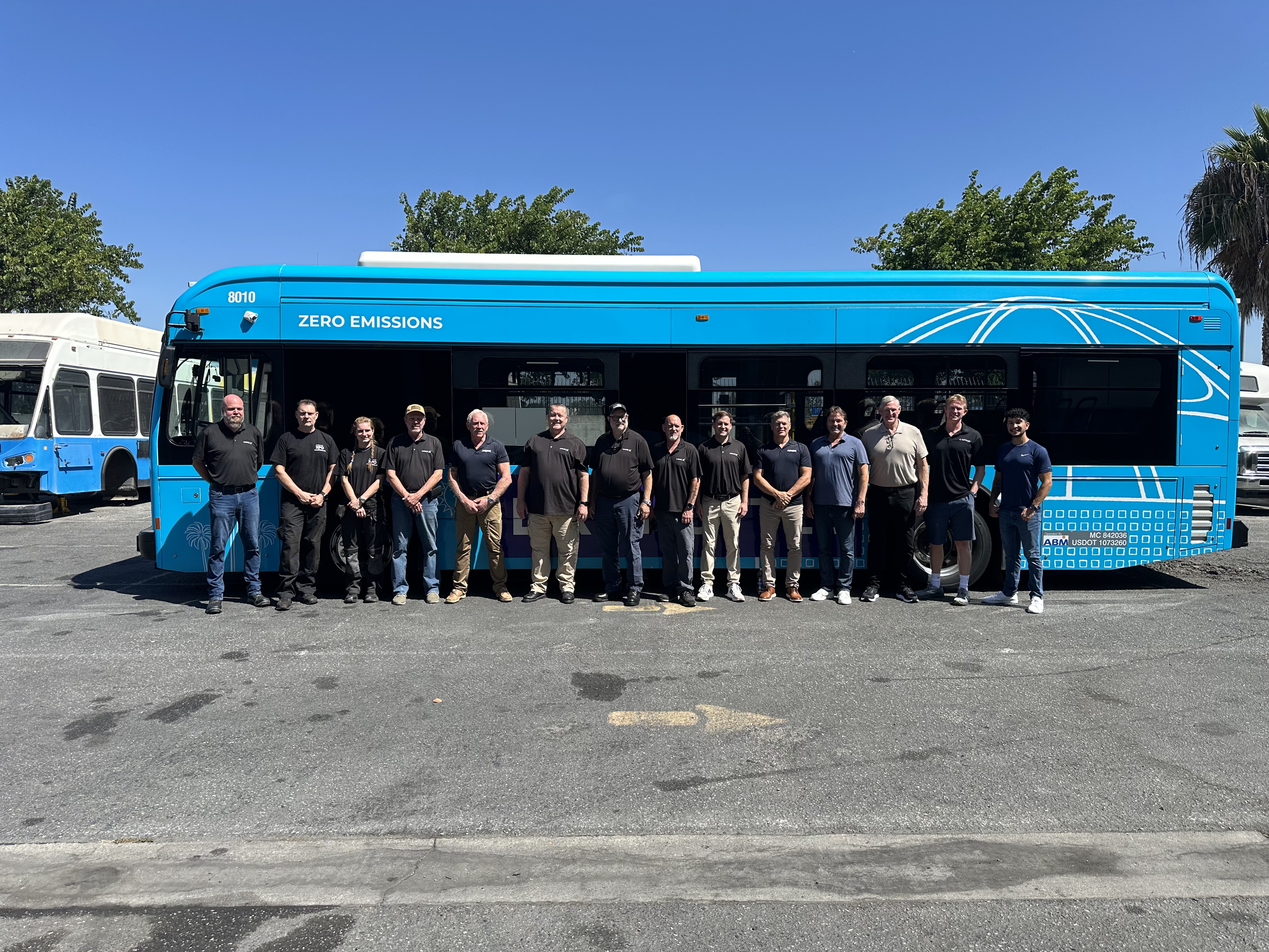 The Accelevate team posing in front of an electric transit bus