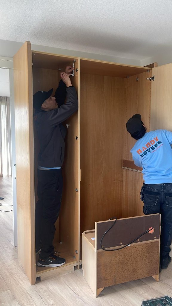 Handy Movers team aan het werk - meubels demonteren bij verhuizing Handy Movers verhuizers demonteren kast bij particuliere verhuizing Amsterdam