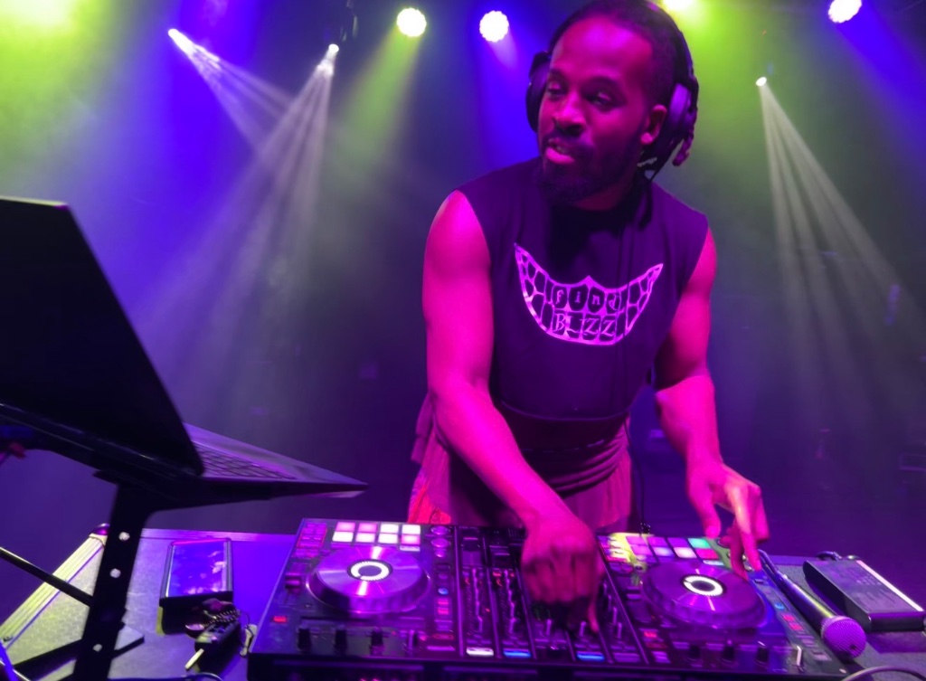 Professional DJ performing on stage with dynamic lighting