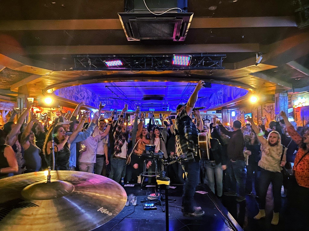 Packed venue with live band and engaged crowd