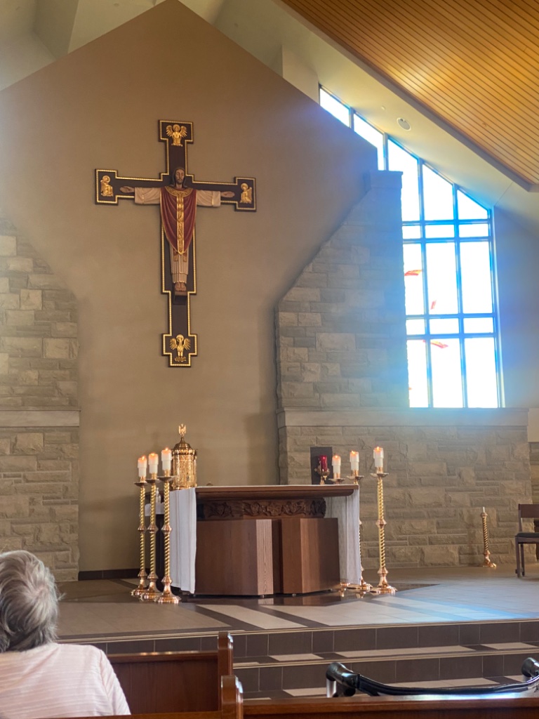 Altar, tabernacle, and candelabras beneath the crucifix