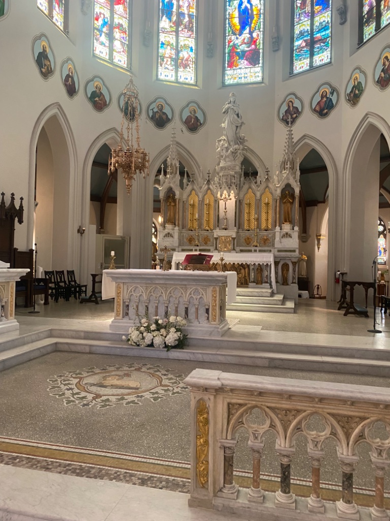 Ornate reredos with statue of the Blessed Virgin Mary and Agnus Dei mosaic floor
