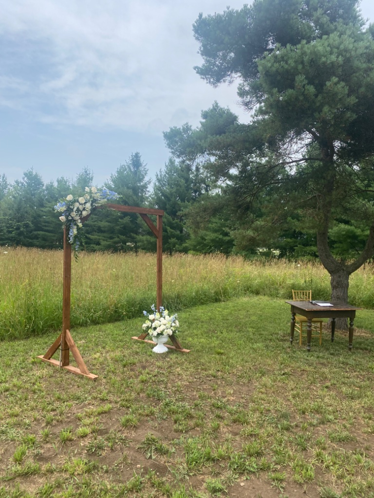 Rustic wooden wedding arch with white and blue florals