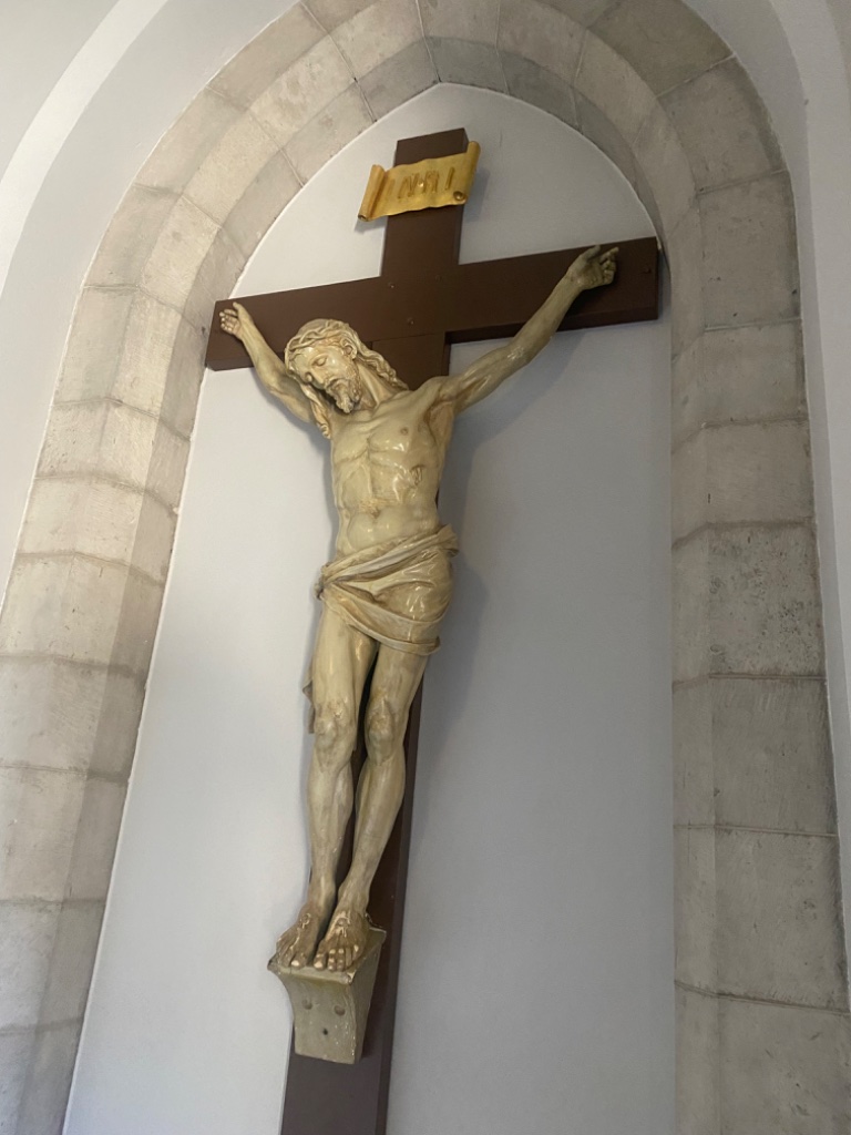 Life-sized crucifix within arched stone niche