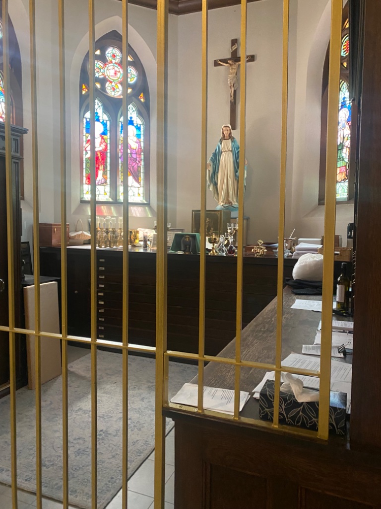 Side chapel with statue of the Virgin Mary behind a grille