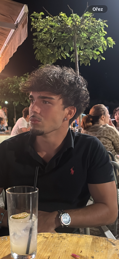 Young man at an outdoor table at night representing premium coaching
