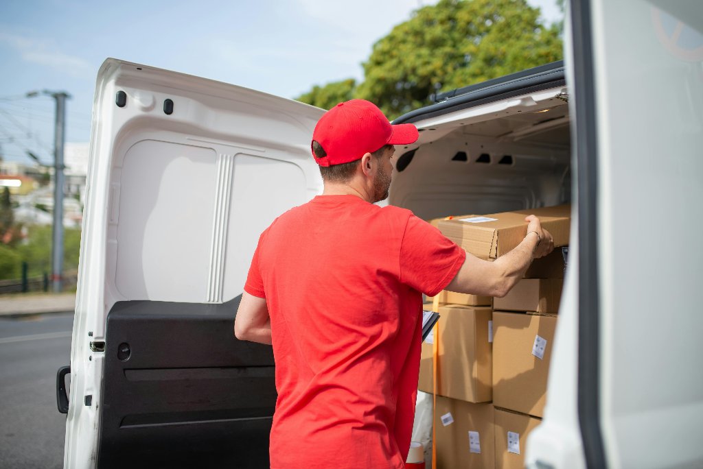 Delivery driver loading packages into van