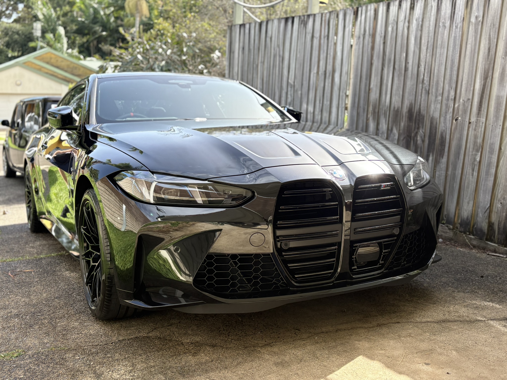 Black BMW M4 parked on driveway after detail