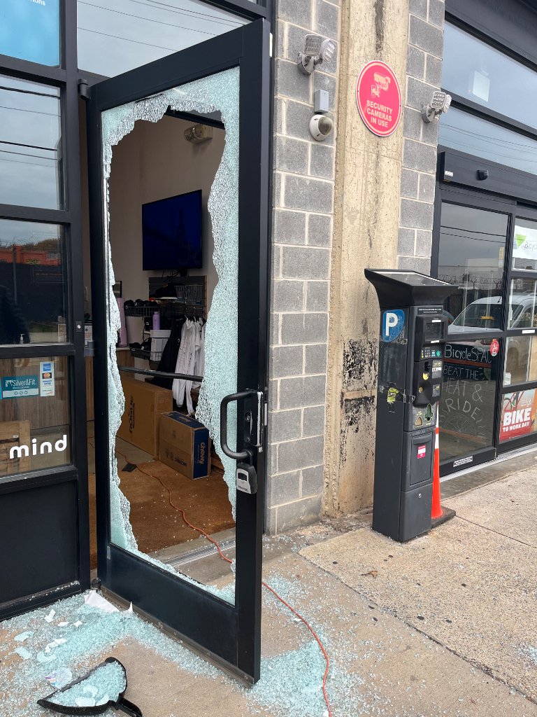 Shattered storefront glass door before board-up