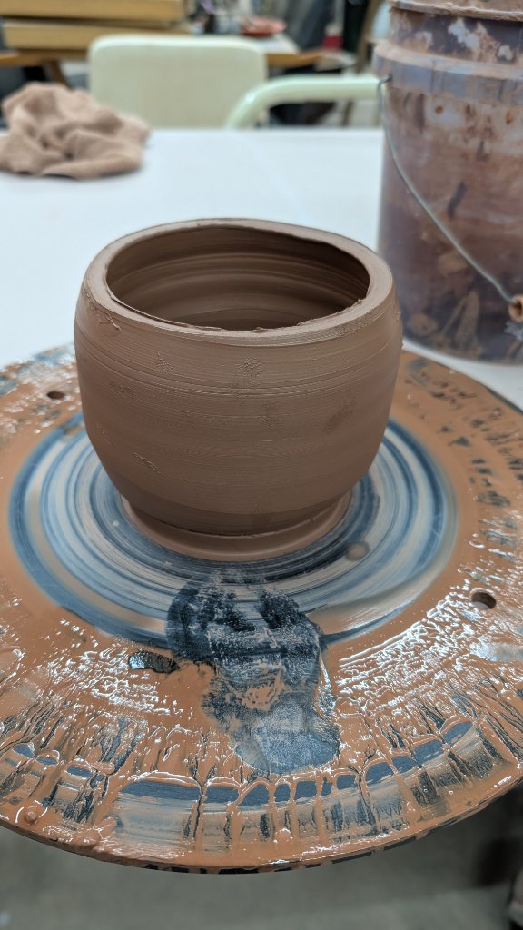 Round clay pot freshly thrown on wheel