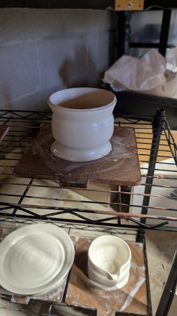 White clay vessel on drying shelf