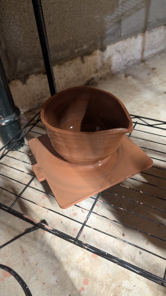 Wet clay bowl on drying rack