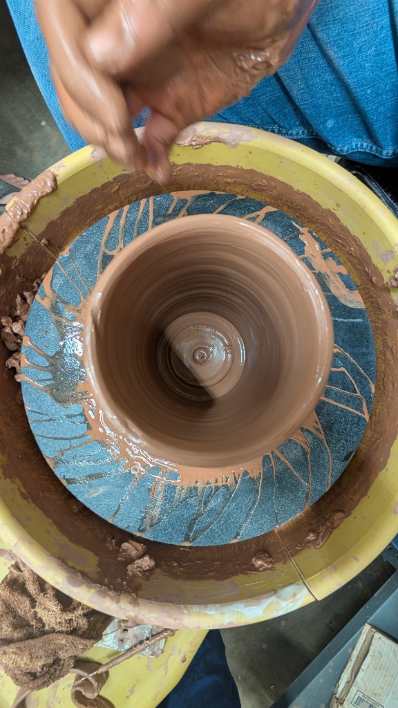 Throwing a clay cylinder on the wheel top view