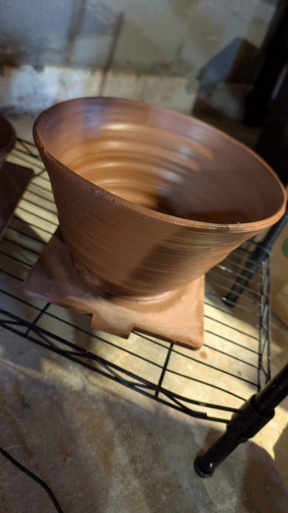 Large flared clay vase on drying rack