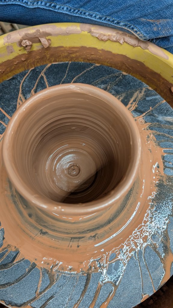 Clay cylinder being formed on the wheel