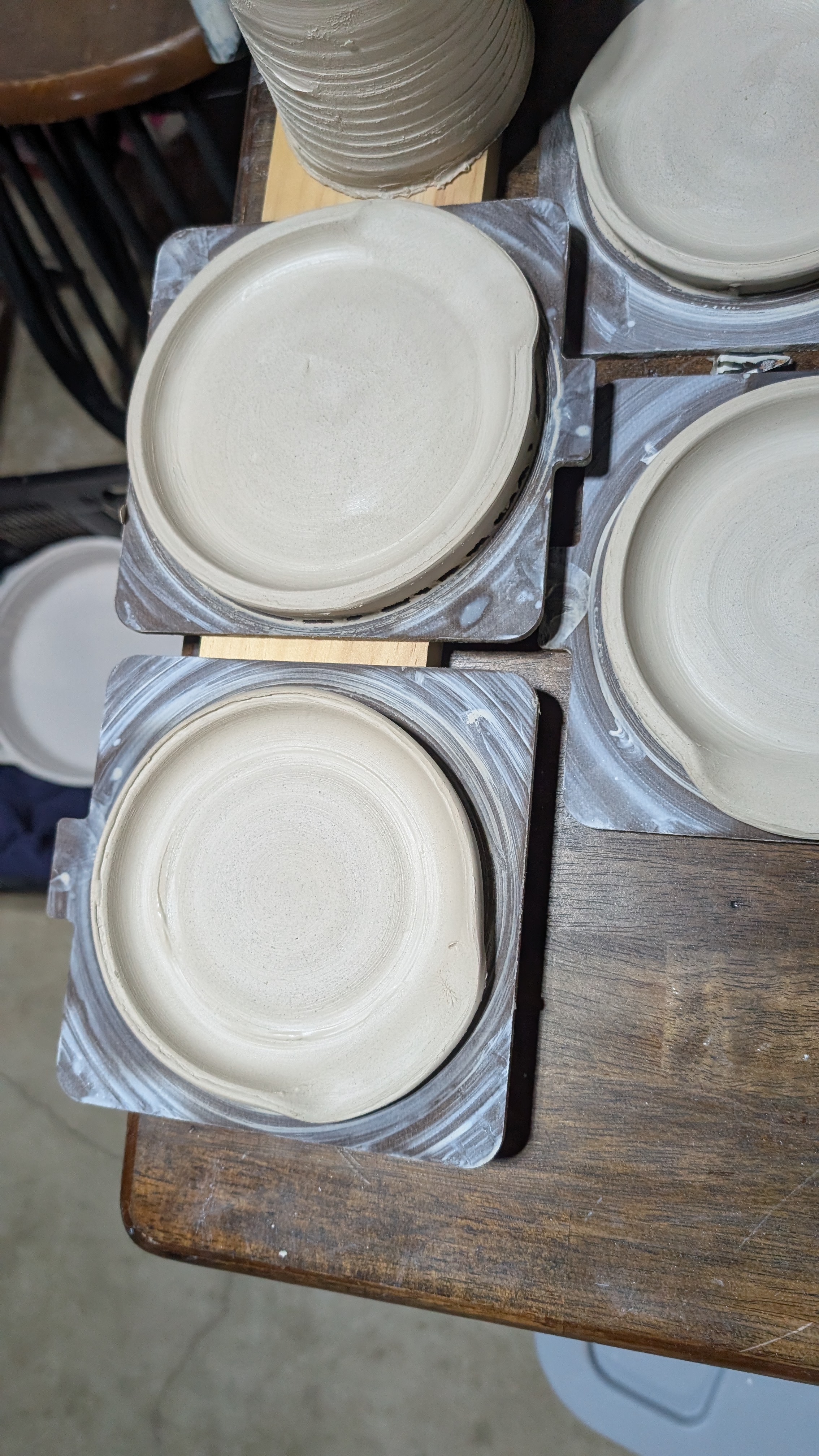 Four clay plates drying on wheel bats
