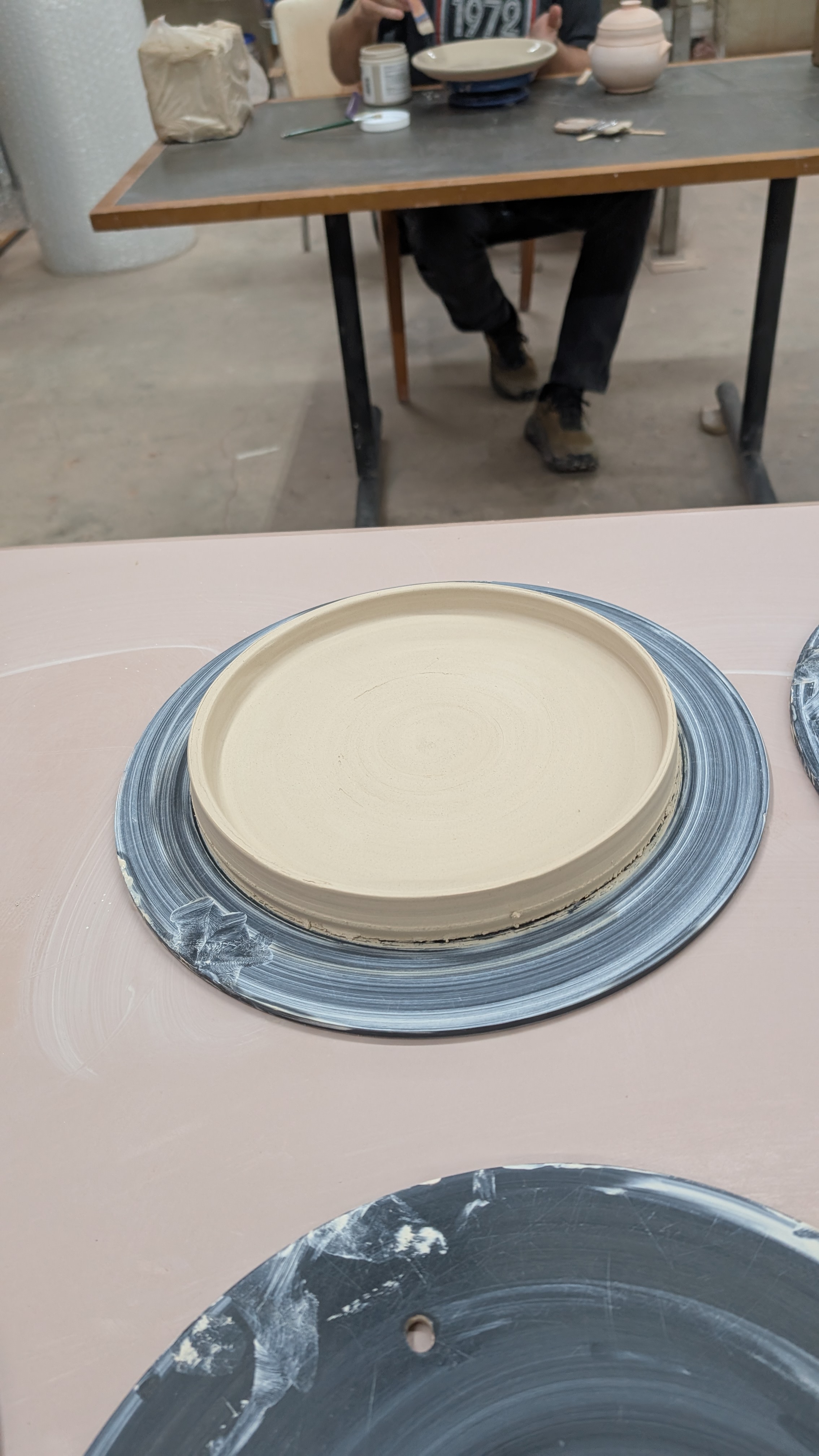 Freshly thrown clay plate on wheel bat