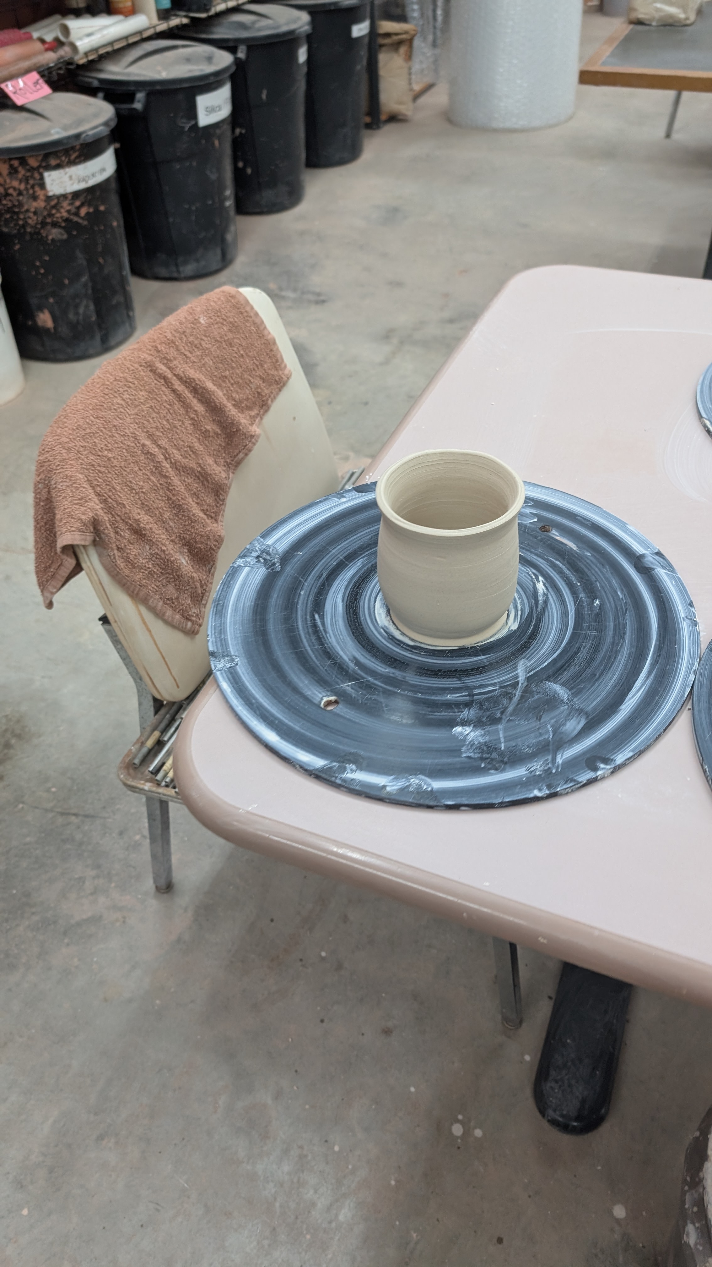 Unfired clay tumbler on black wheel bat