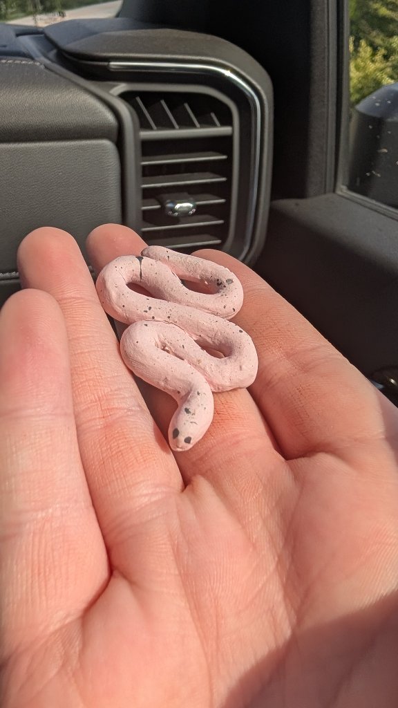 Small pink ceramic snake sculpture