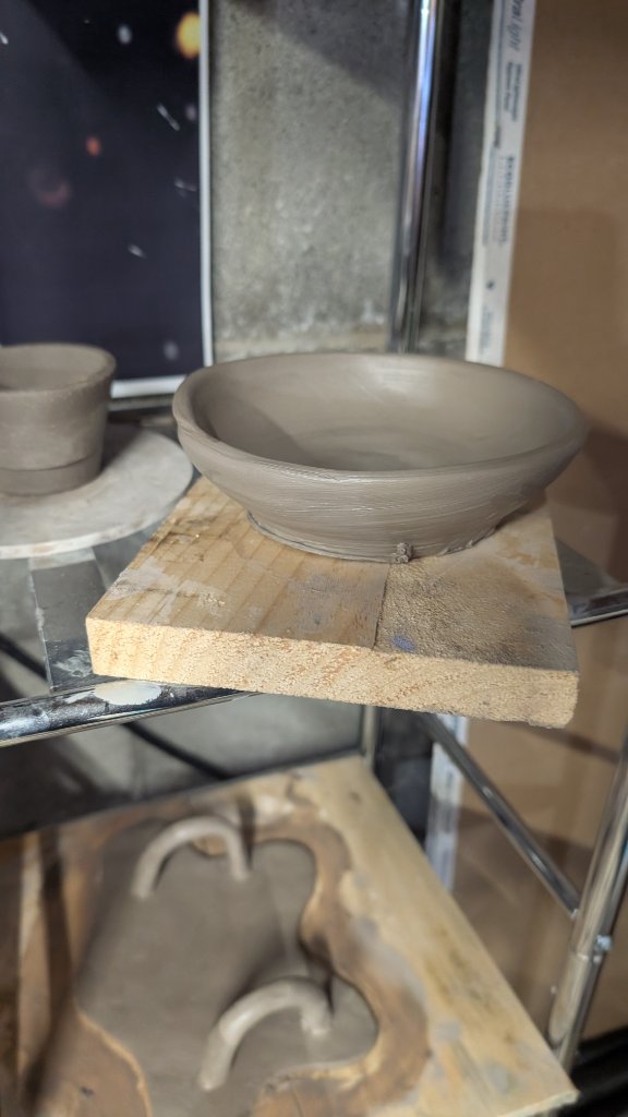 Small grey clay saucer dish drying on board