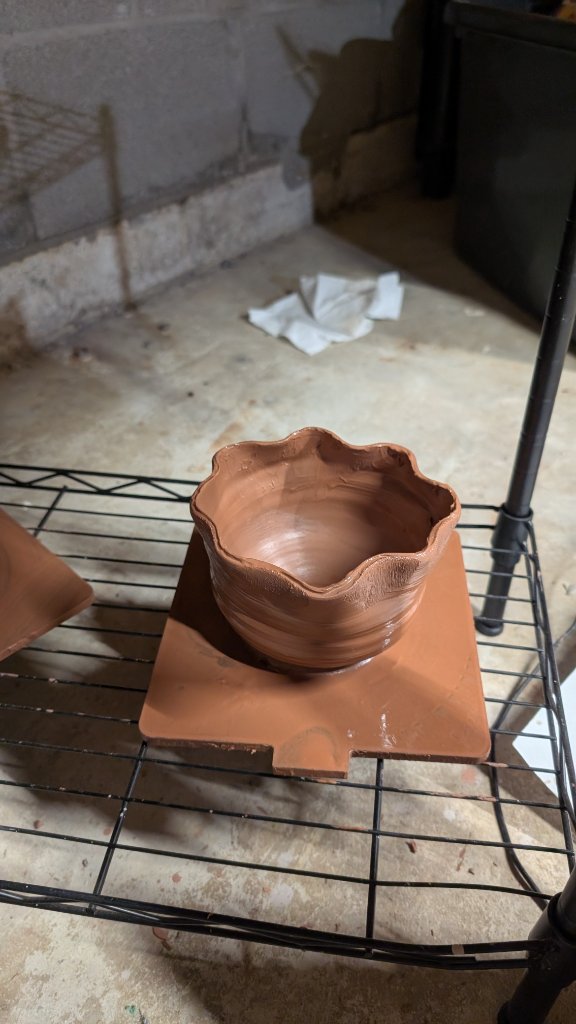 Ruffled edge clay bowl on shelf