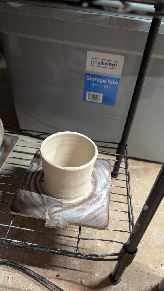 Unfired clay cylinder on drying board