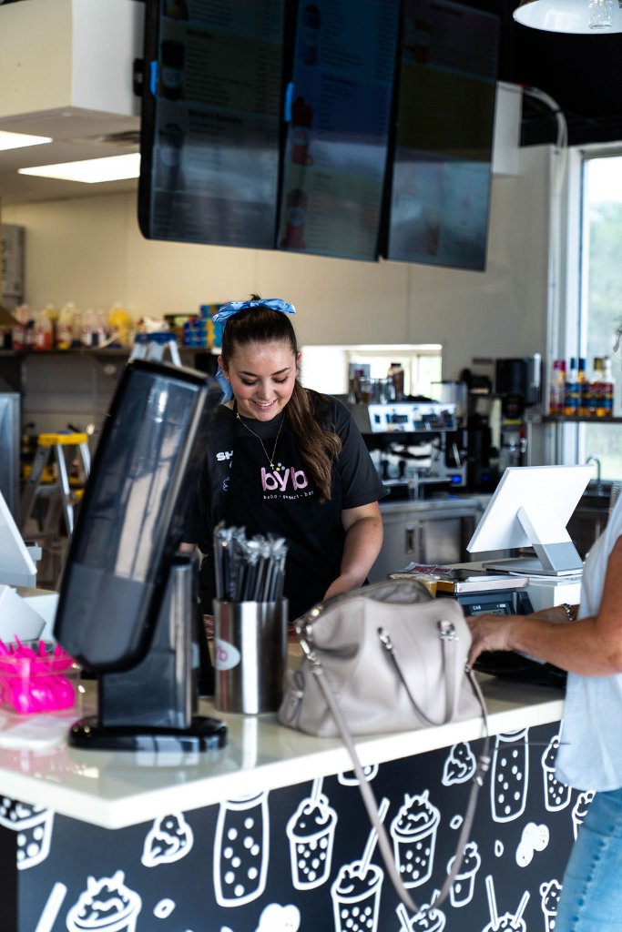 BYB team member smiling at the counter in Claremore, OK