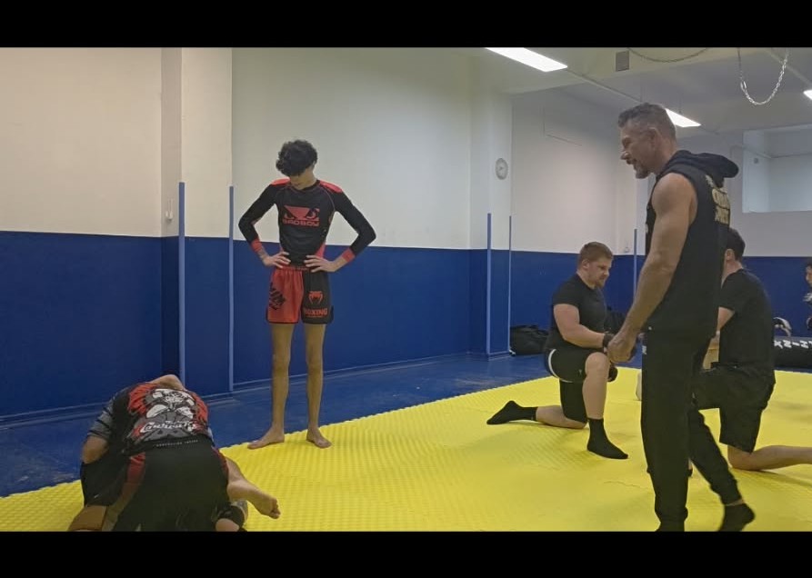 Atleti in allenamento MMA e Krav Maga nella palestra KravMMA Extreme Torino con tatami giallo