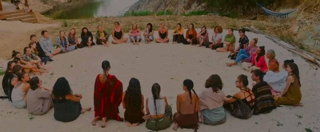 Women sitting in a sacred circle on the sand