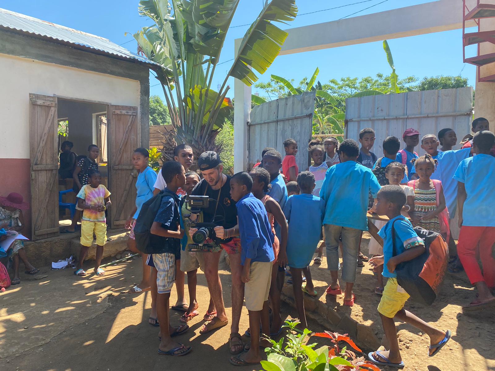 Intern filming with local school children