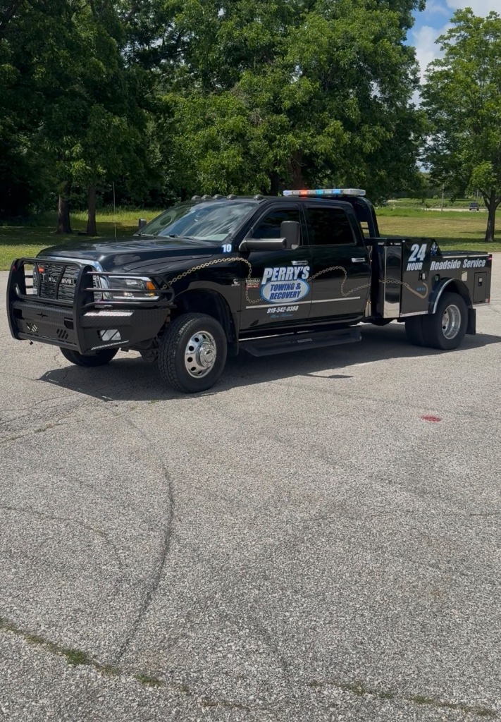 Perry's black RAM 24-Hour Roadside Service truck — side view