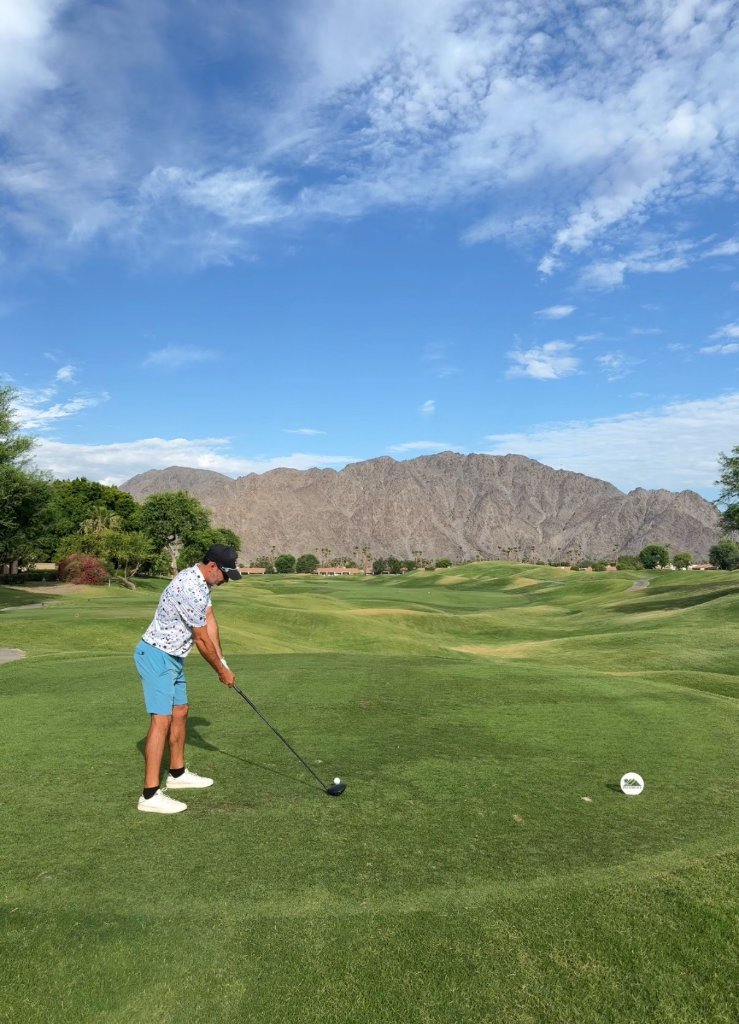 Golfer on course with mountain backdrop