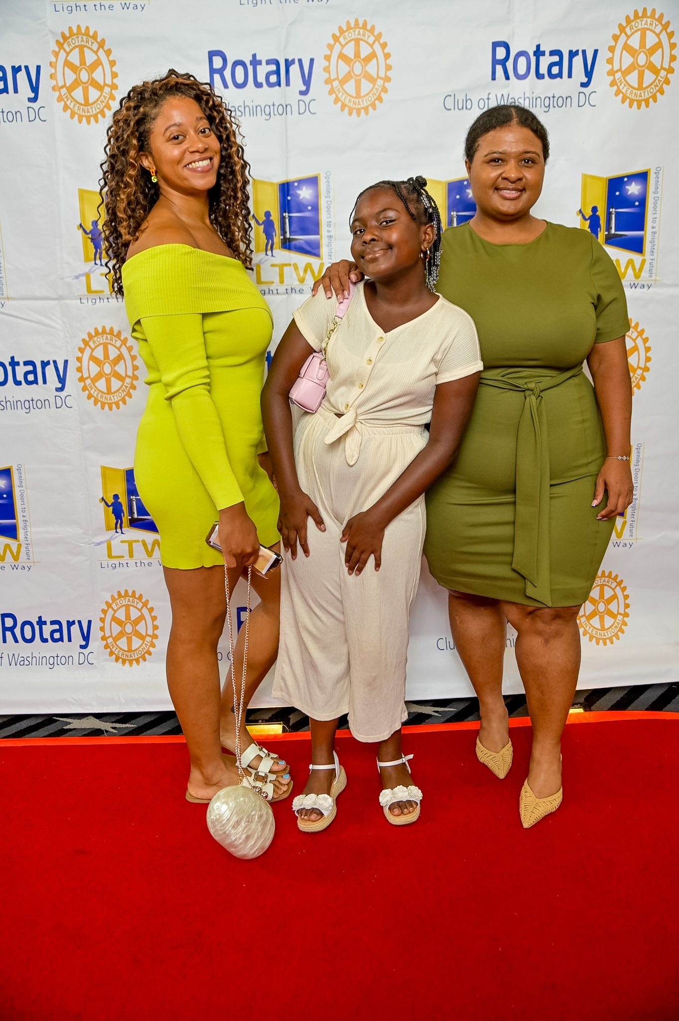 Three guests in green posing on the Red Carpet at the 2026 Premiere