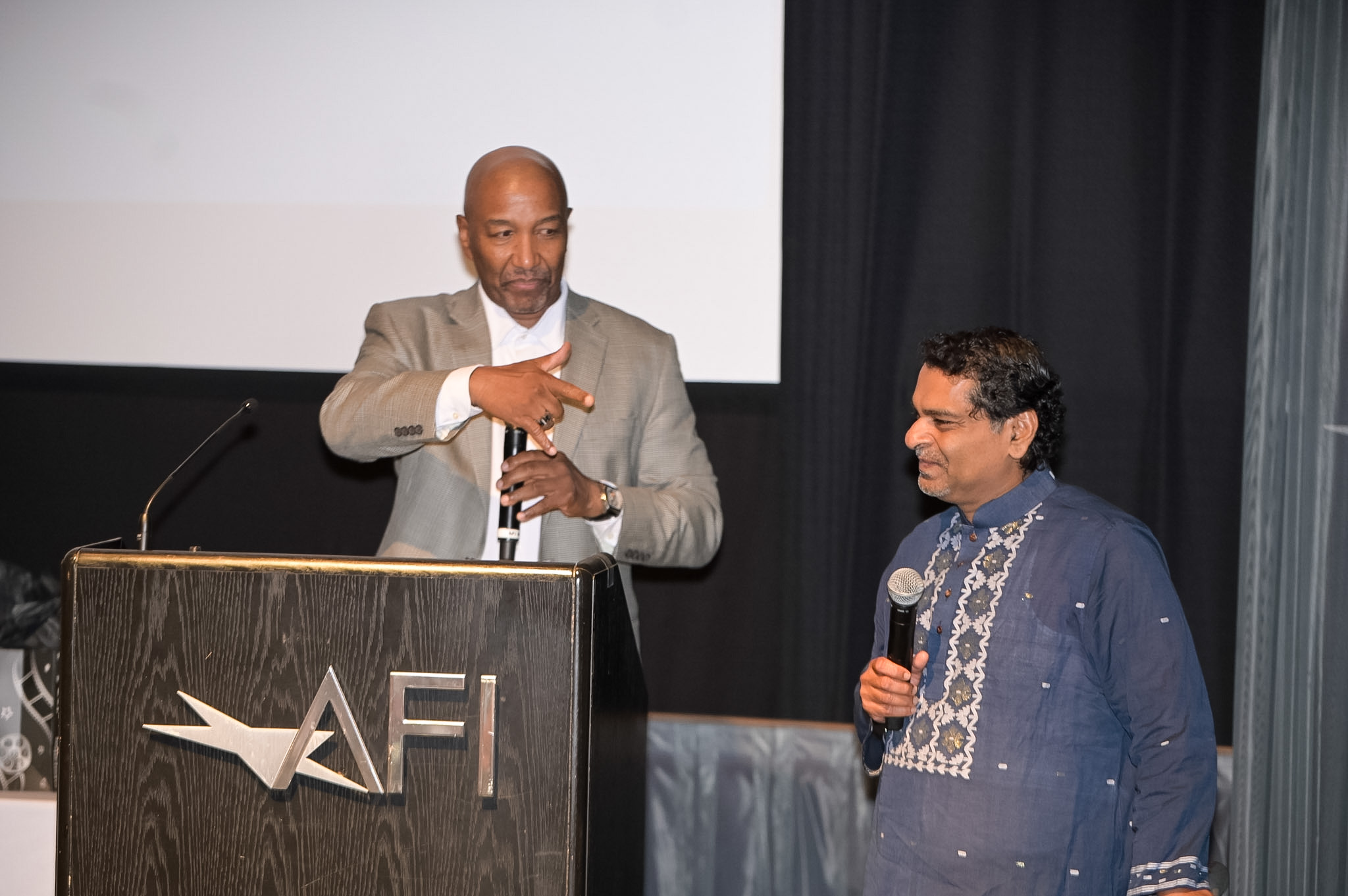 Two men speaking on stage at the 2026 Red Carpet Premiere