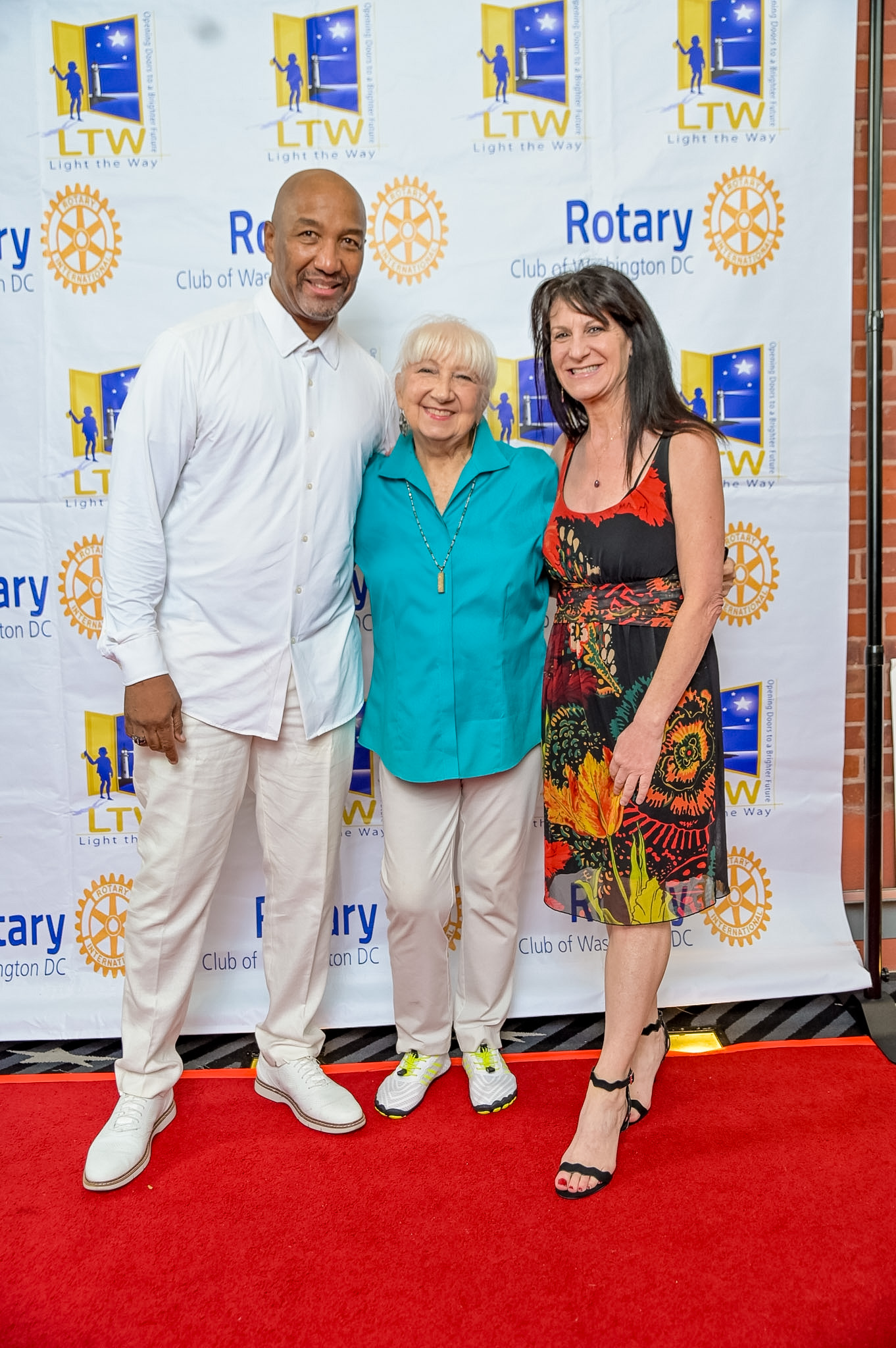 Three adults posing on the Red Carpet at the 2026 Premiere
