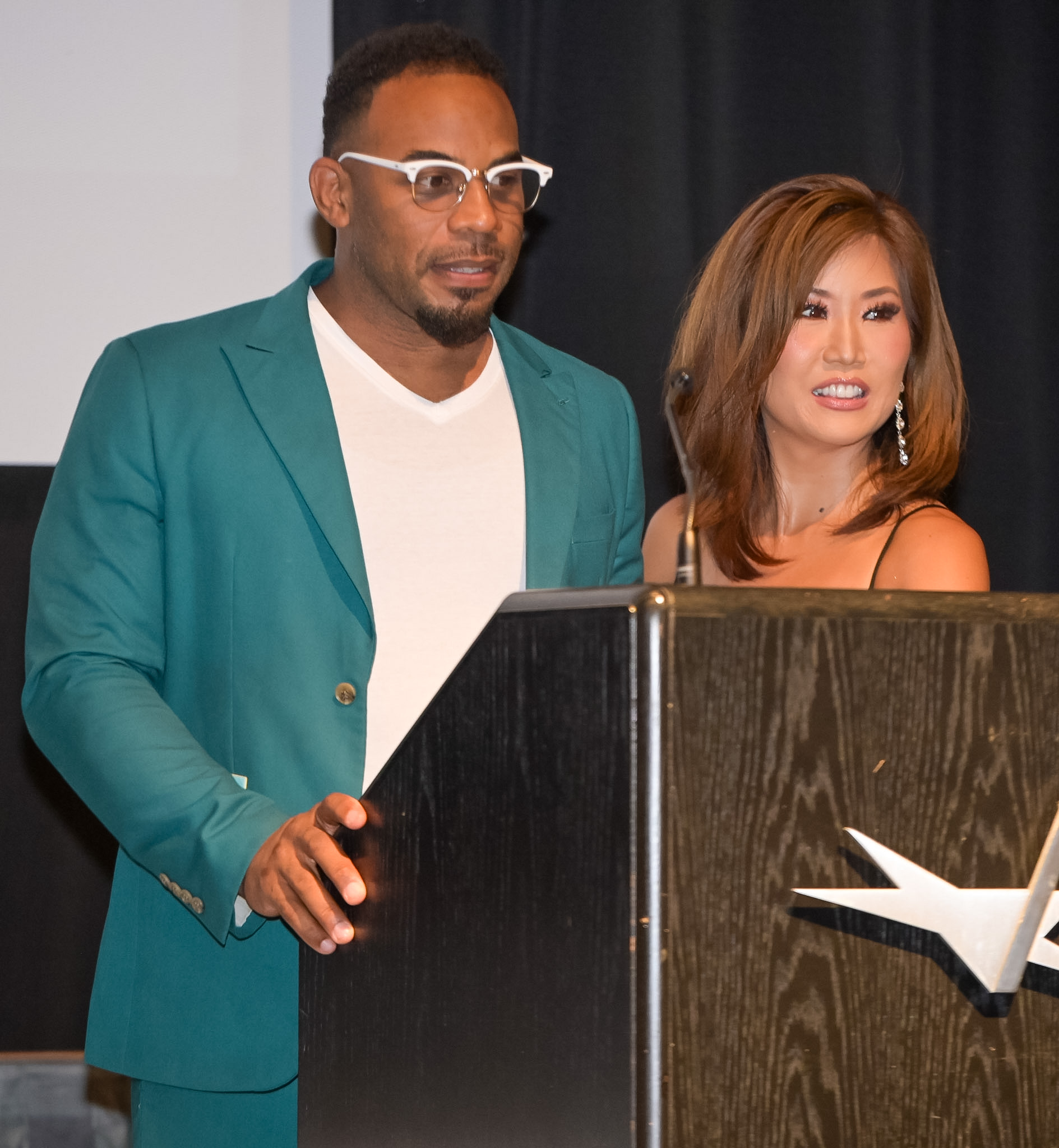 Two speakers behind the podium at the 2026 Red Carpet Premiere