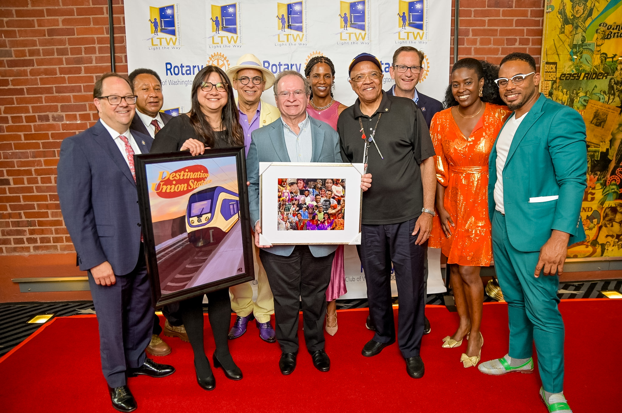 Group of ten guests with framed artwork on the Red Carpet at the 2026 Premiere